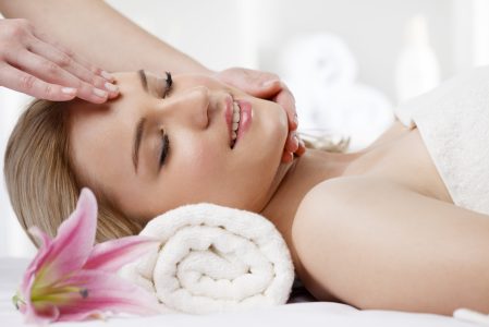 Close-up of a young and beautiful woman enjoying massage at spa centre.